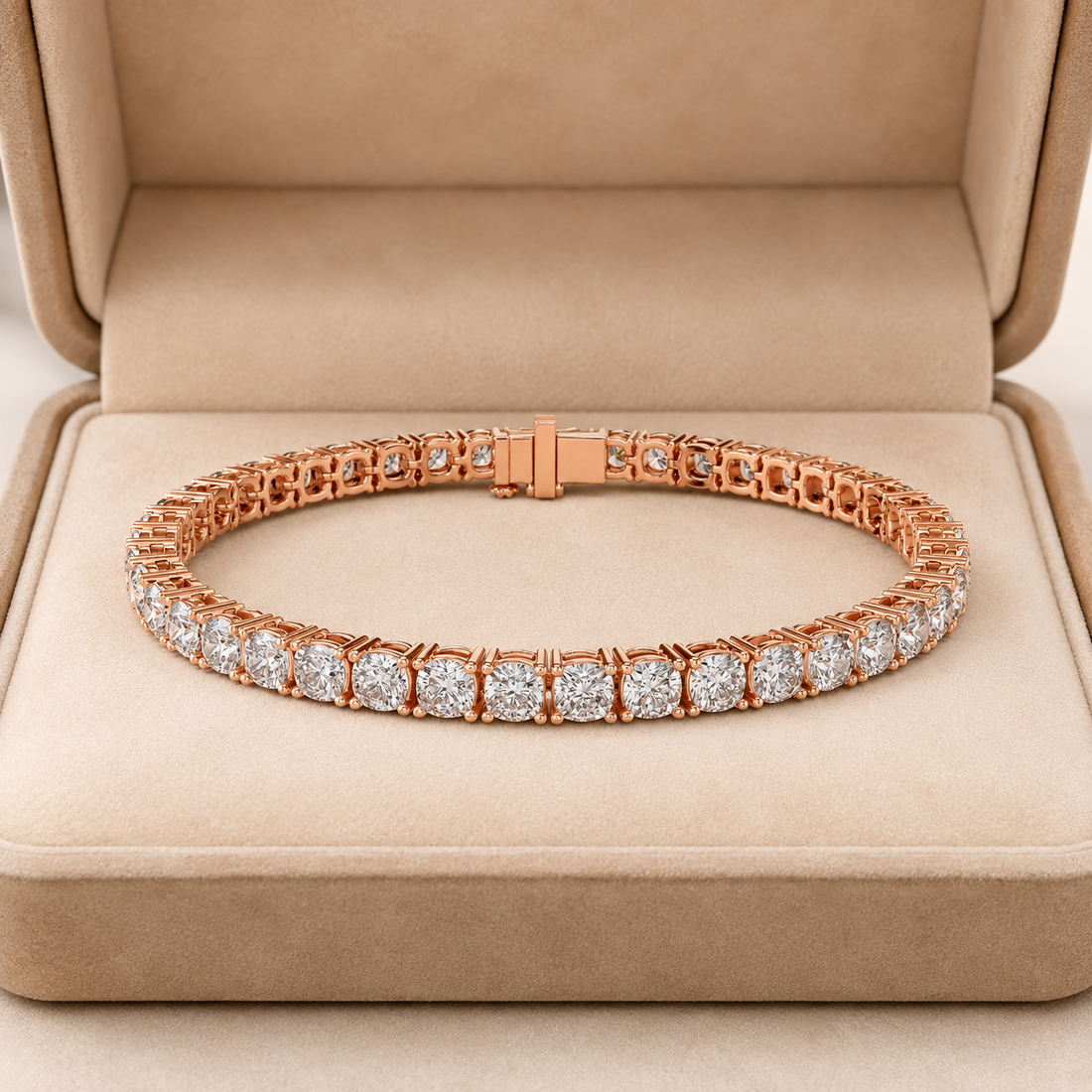 A rose gold tennis bracelet with round-cut clear stones, displayed inside an open beige jewelry box.
