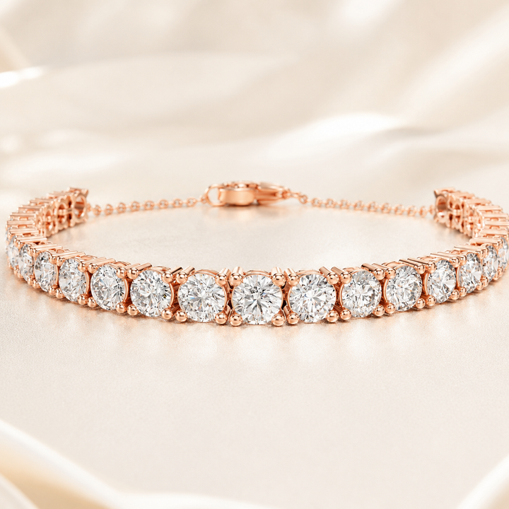 A rose gold tennis bracelet with round-cut clear gemstones, displayed on a soft beige satin fabric background.