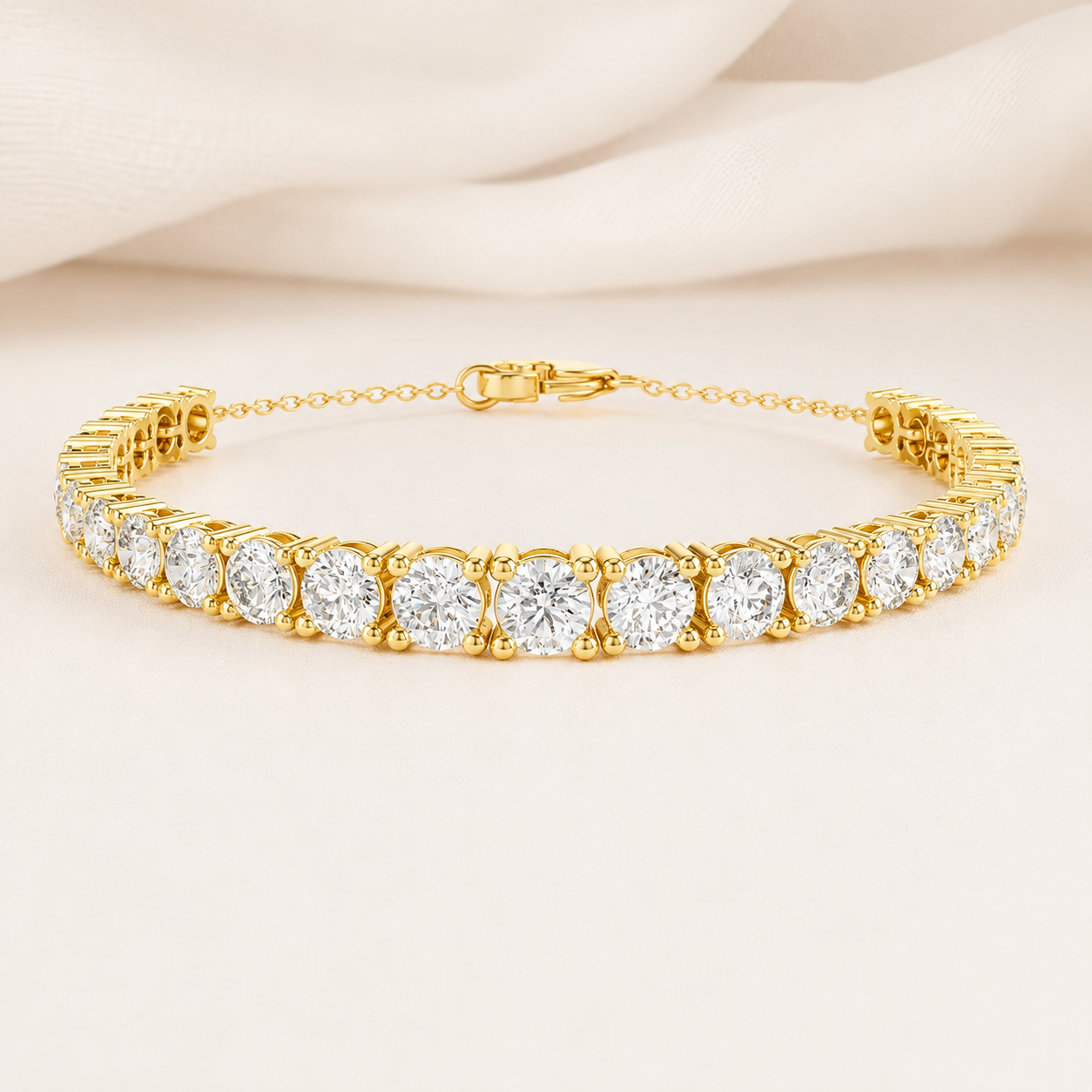 A yellow gold tennis bracelet with round-cut clear gemstones, displayed on a soft beige fabric background.