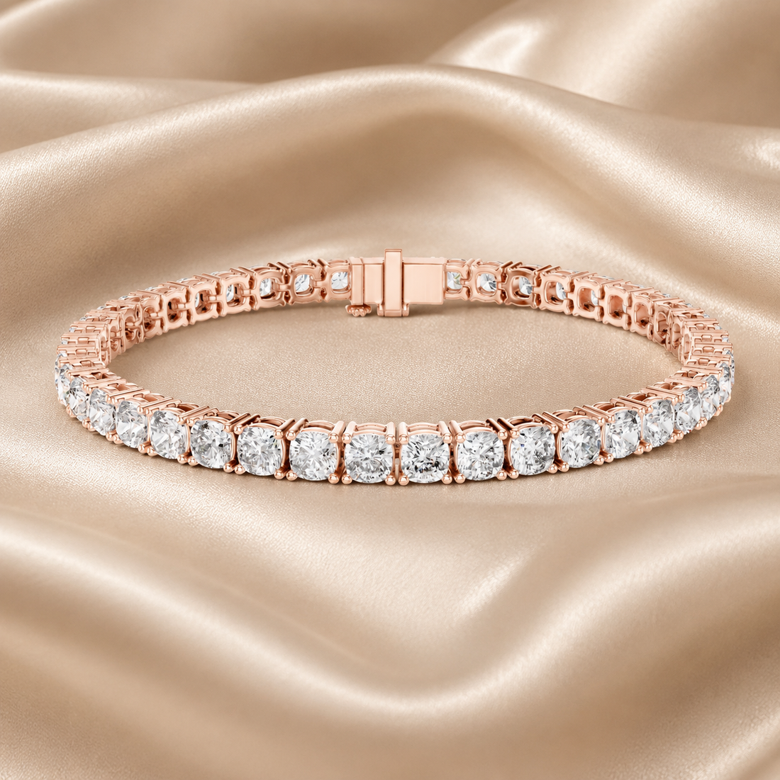 A rose gold tennis bracelet with clear round-cut gemstones, displayed on a draped champagne satin fabric background.