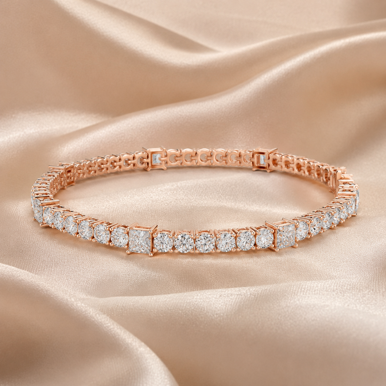 A rose gold tennis bracelet with brilliant and round-cut clear stones, displayed on a draped champagne satin fabric background.