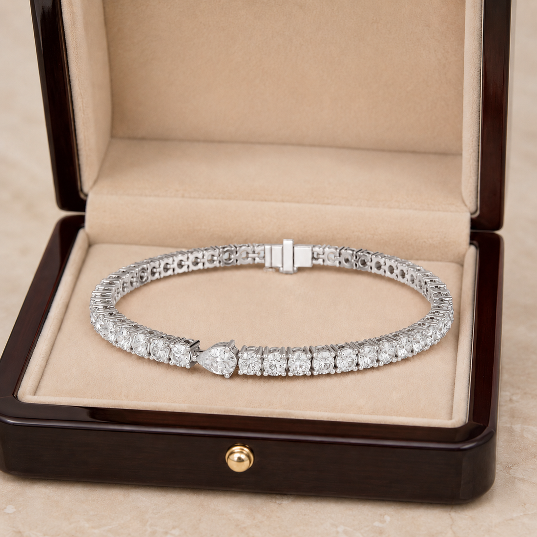 A diamond tennis bracelet displayed inside an open dark wood jewelry box with a beige velvet lining.