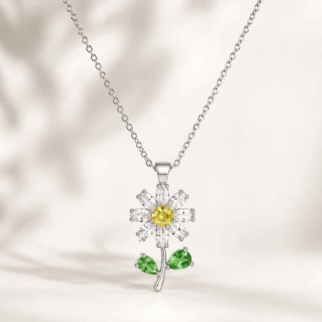 Close-up of a yellow gold lab-grown diamond flower pendant with green leaf accents by Kiashaa Jewellery