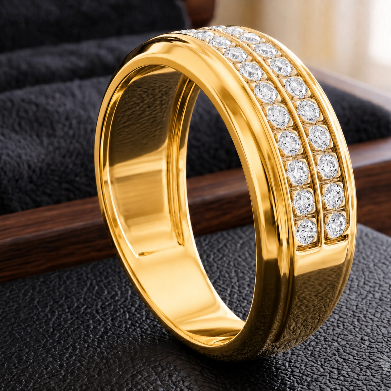 A polished yellow gold band ring with two rows of round clear gemstones, displayed on a textured black surface.