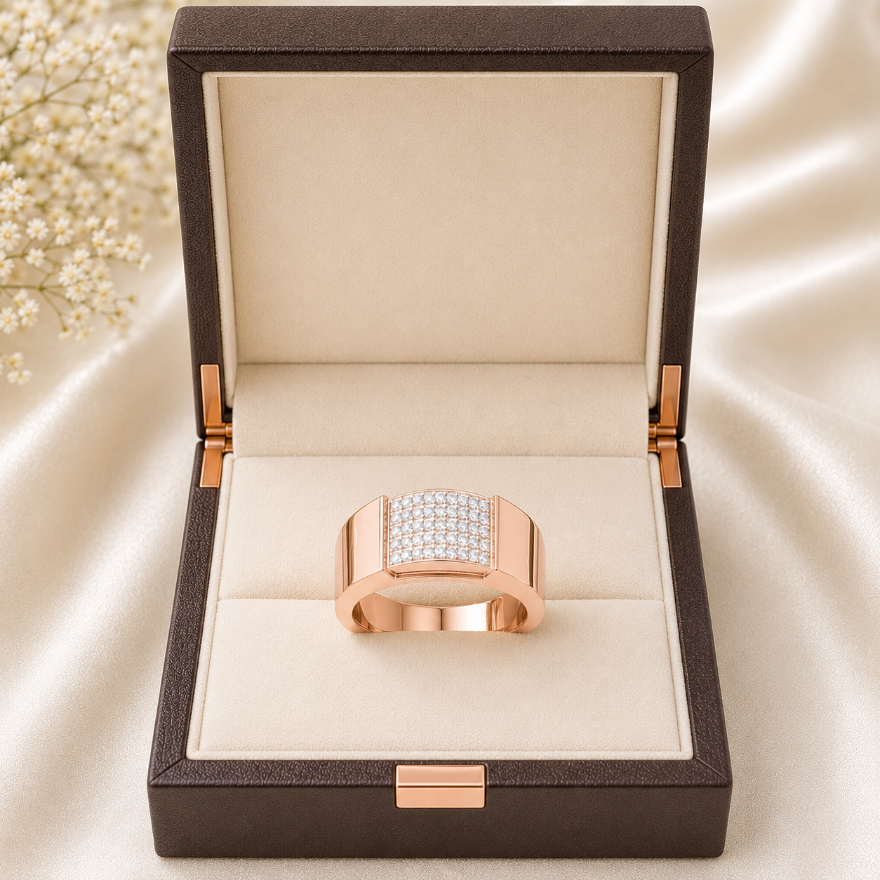 A rose gold ring with a square pavé crystal center, presented inside an open dark brown textured jewelry box on a beige satin fabric background.
