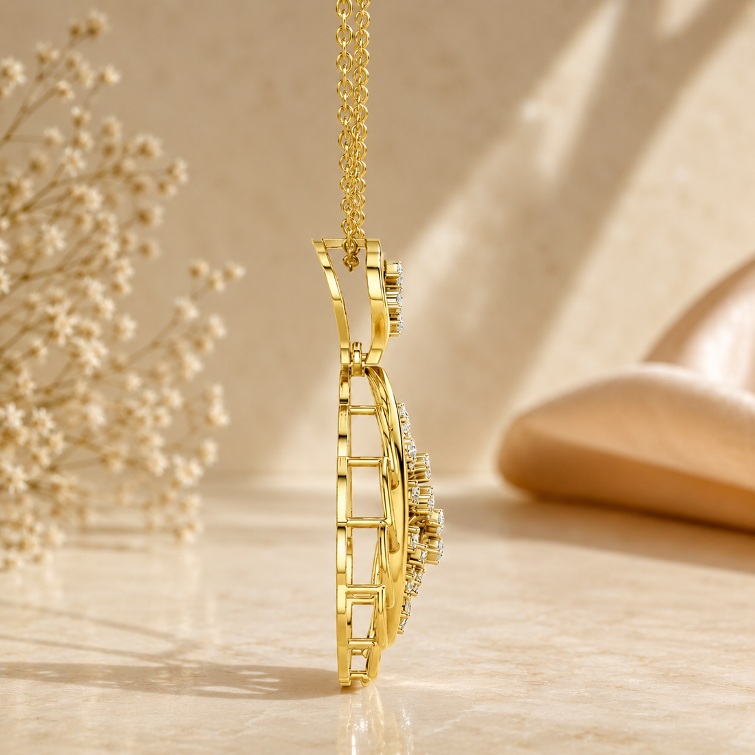 A gold pendant necklace with a geometric, ladder-like side profile and small clear stones, shown hanging on a gold chain against a warm beige background with soft shadows and dried flowers.