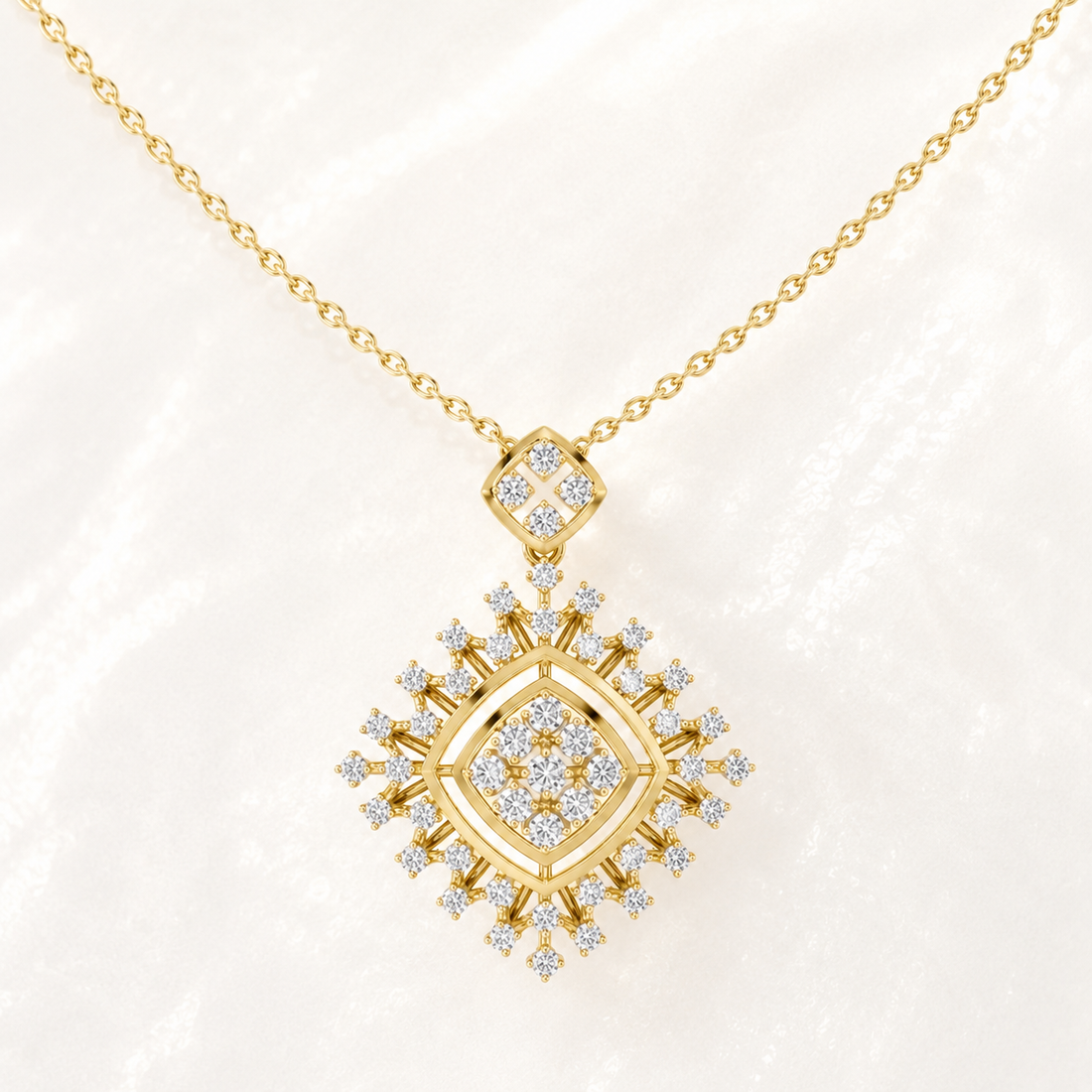 A gold pendant necklace featuring a multi-layered diamond-shaped design set with clear gemstones, displayed on a soft white textured background.