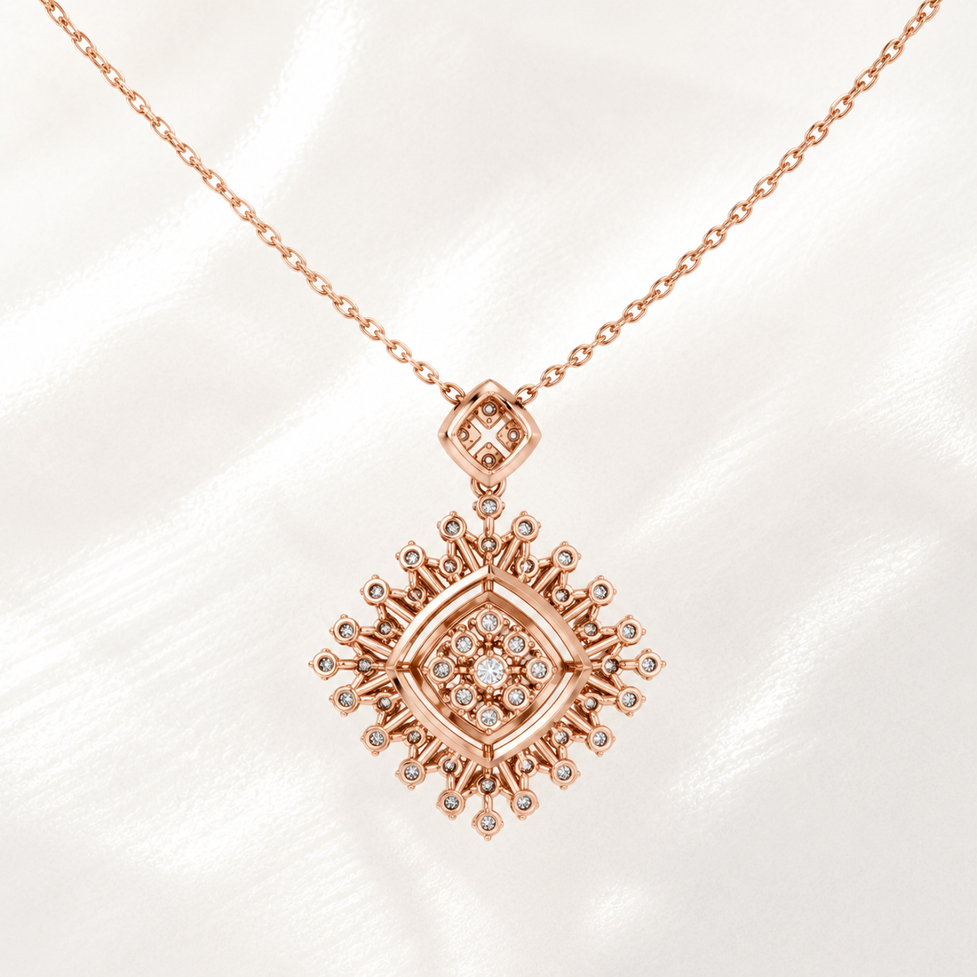 Rose gold necklace with a diamond-encrusted geometric pendant on a white satin background.