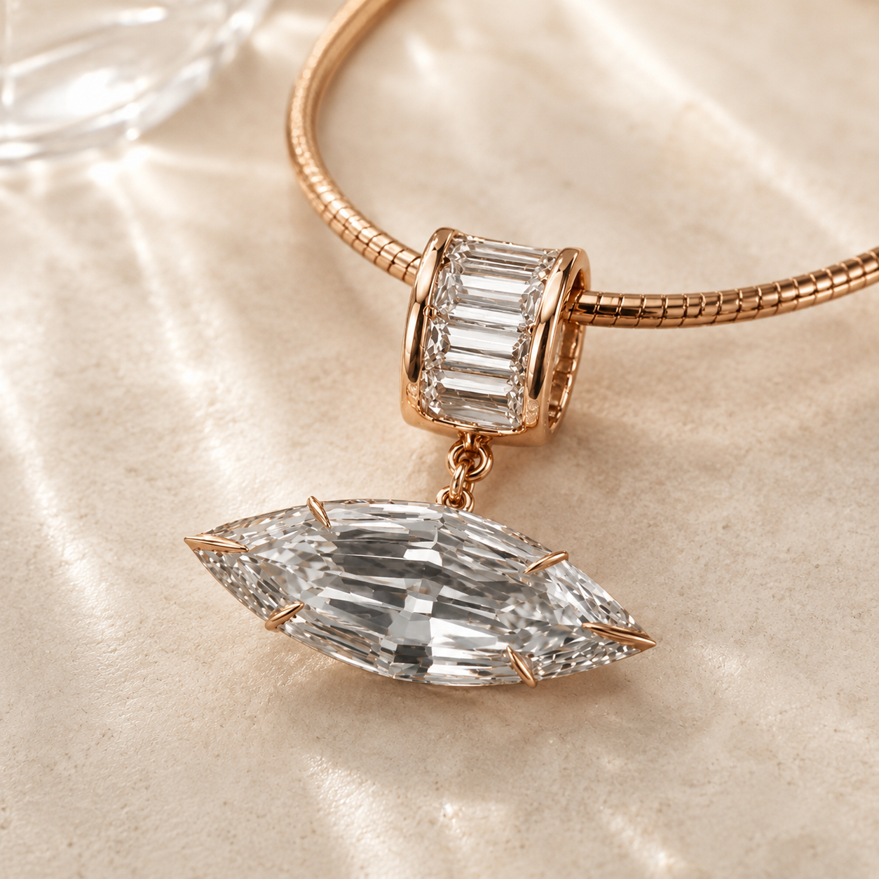 Rose gold bangle bracelet with a marquise-cut clear crystal pendant and a matching rectangular clear crystal charm, displayed on a beige fabric background.