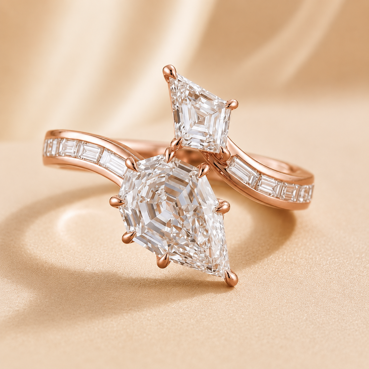 Rose gold ring set with two large clear gemstones, one pear-cut and one marquise-cut, accented with baguette stones on the band, photographed on a warm beige satin-like background.