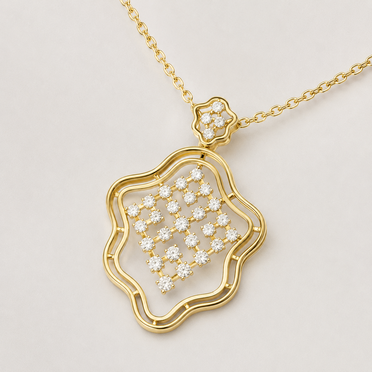 A gold pendant necklace featuring a wavy openwork border and a central cluster of small clear stones, suspended from a delicate gold chain on a light gray background.