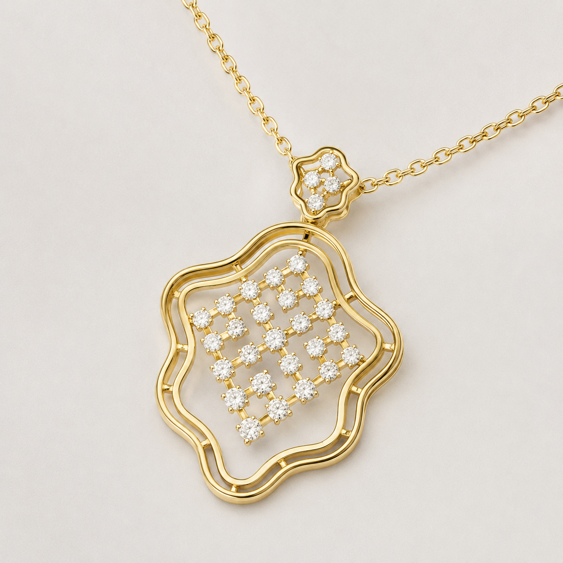 A gold pendant necklace featuring a wavy openwork border and a central cluster of small clear stones, suspended from a delicate gold chain on a light gray background.