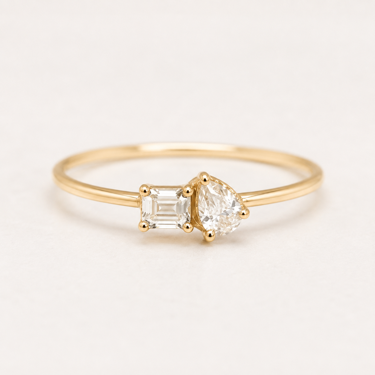 Kiashaa Jewellery 1 CT emerald and pear diamond Toi et Moi ring in polished yellow gold with a slim band