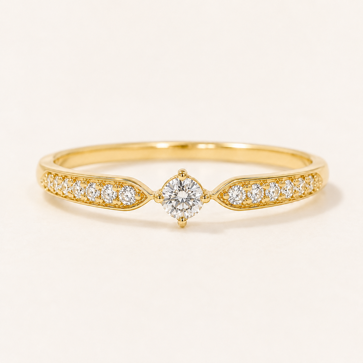 A yellow gold diamond ring with a marquise-cut center stone and pavé-set diamonds along the band, shown on a clean off-white background.