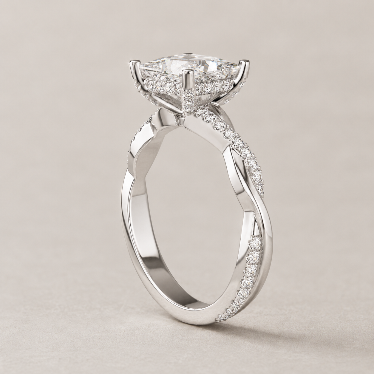 A silver-toned diamond engagement ring with a round-cut center stone and pavé-set diamonds along the twisted shank, photographed on a neutral light beige background.