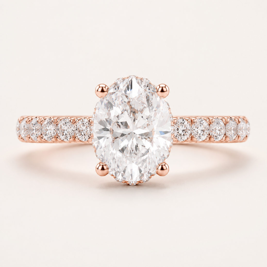 Rose gold engagement ring featuring a large oval-cut center diamond and a pavé diamond band, set against a clean off-white background.