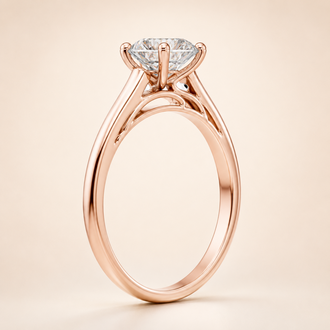 A rose gold solitaire engagement ring with a round brilliant-cut diamond, shown on a clean, light beige background.