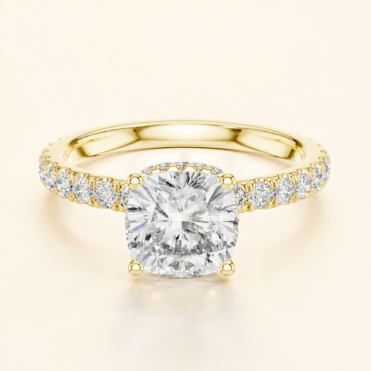 A yellow gold engagement ring featuring a large round brilliant-cut center diamond and a pavé-set diamond band, shown on a light cream background.