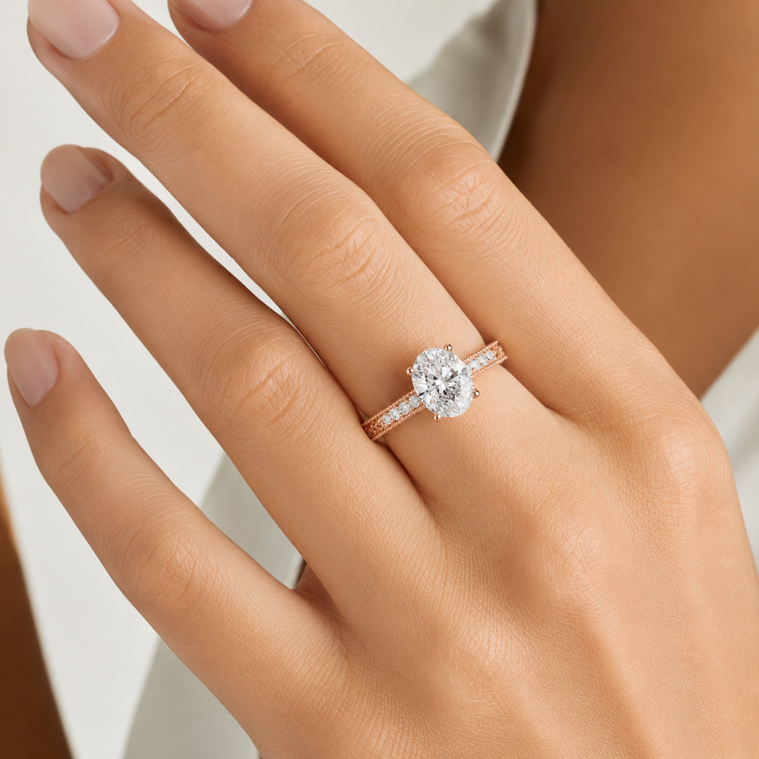 A close-up of a hand wearing a rose gold engagement ring with a round-cut clear center stone and a pavé band.