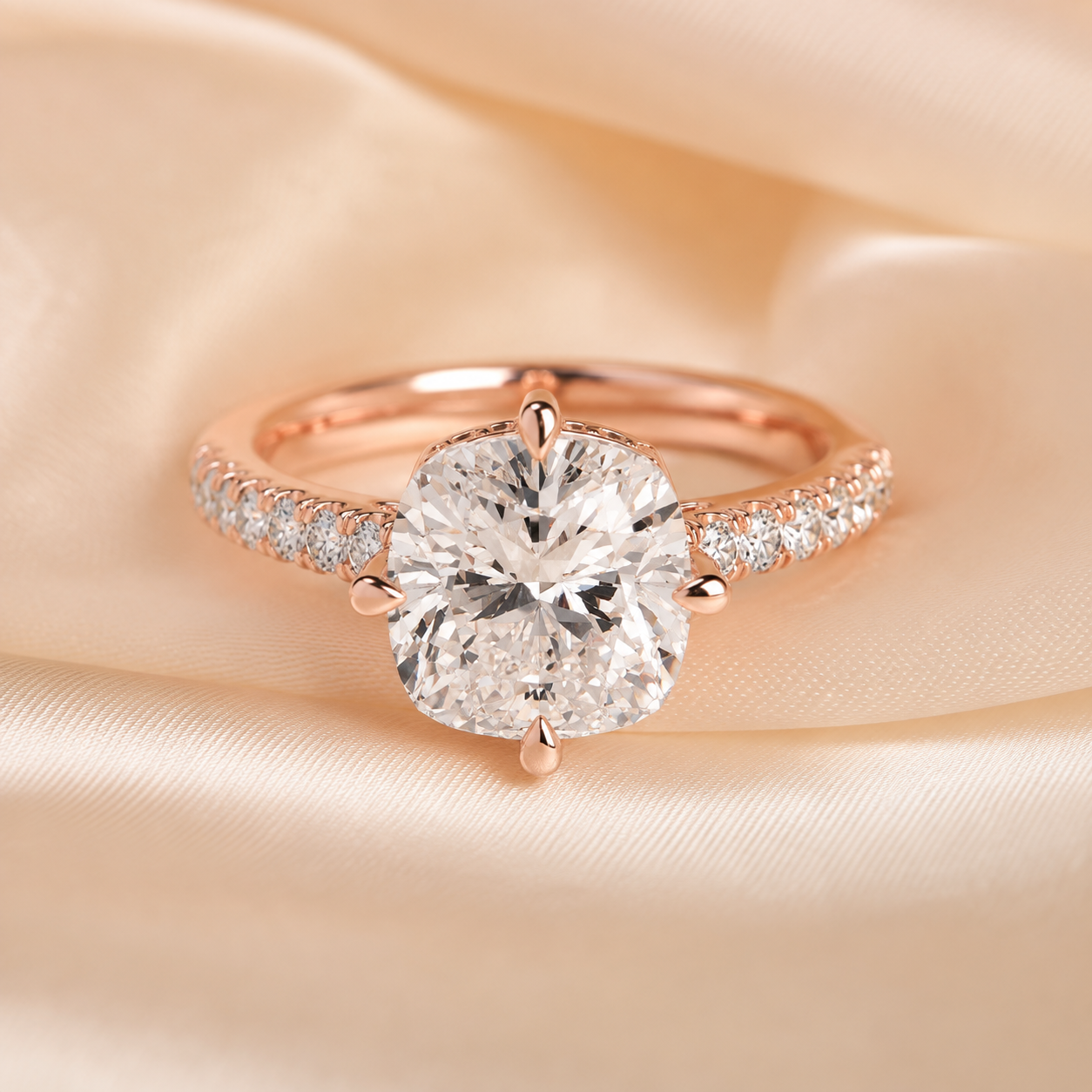 Rose gold engagement ring with a large round brilliant-cut center stone and a pavé-set band, displayed on a soft beige satin fabric background.