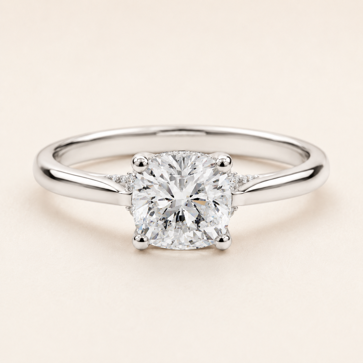 A classic solitaire engagement ring featuring a round brilliant-cut diamond set in a polished silver-colored metal band, photographed on a clean, solid light beige background.