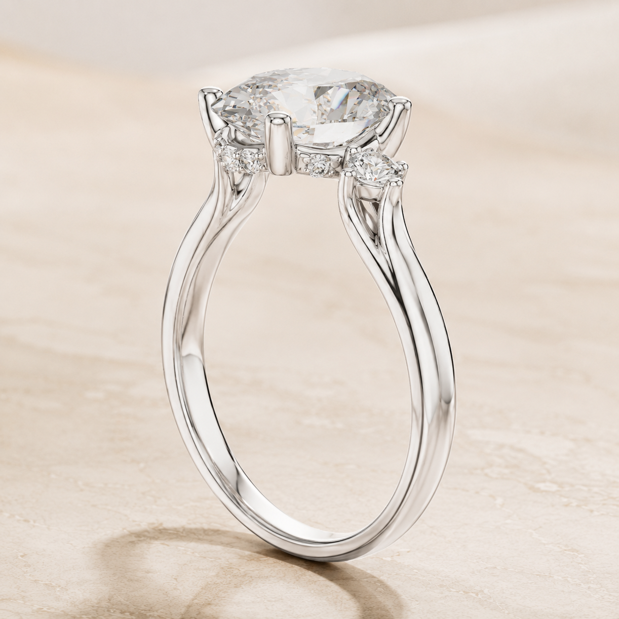 A silver-tone solitaire engagement ring with a round brilliant-cut center stone and small side stones, shown on a light beige textured surface.