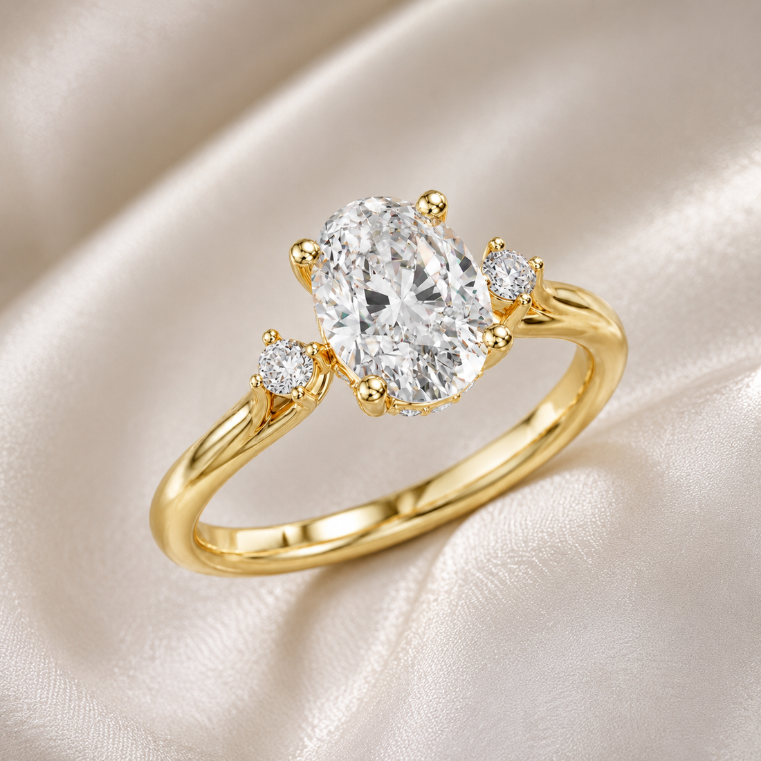 A yellow gold ring featuring a large oval-cut clear center stone and two smaller round stones on either side, displayed on a soft cream satin fabric background.