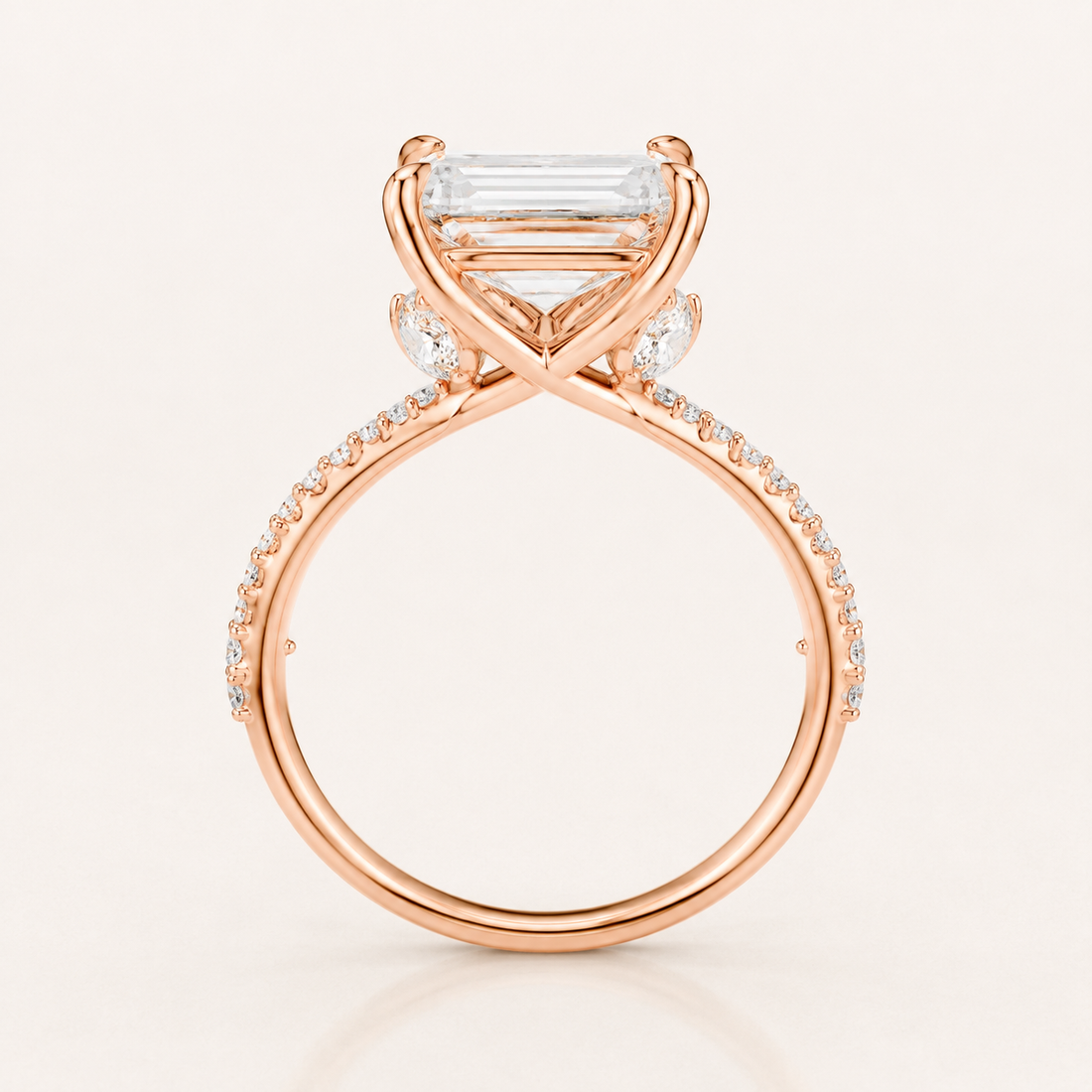 Rose gold ring with a large rectangular baguette-cut clear gemstone and small accent stones along the band, shown on a clean off-white background.