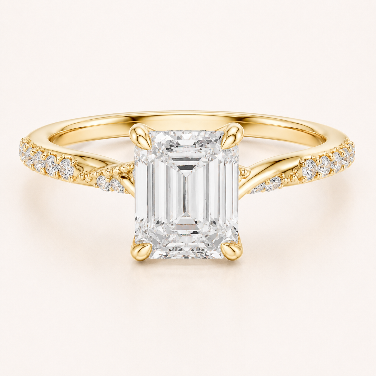 An emerald-cut diamond engagement ring in yellow gold, featuring a large central diamond and smaller diamonds set along the shoulders of a polished band, shown on a light cream background.