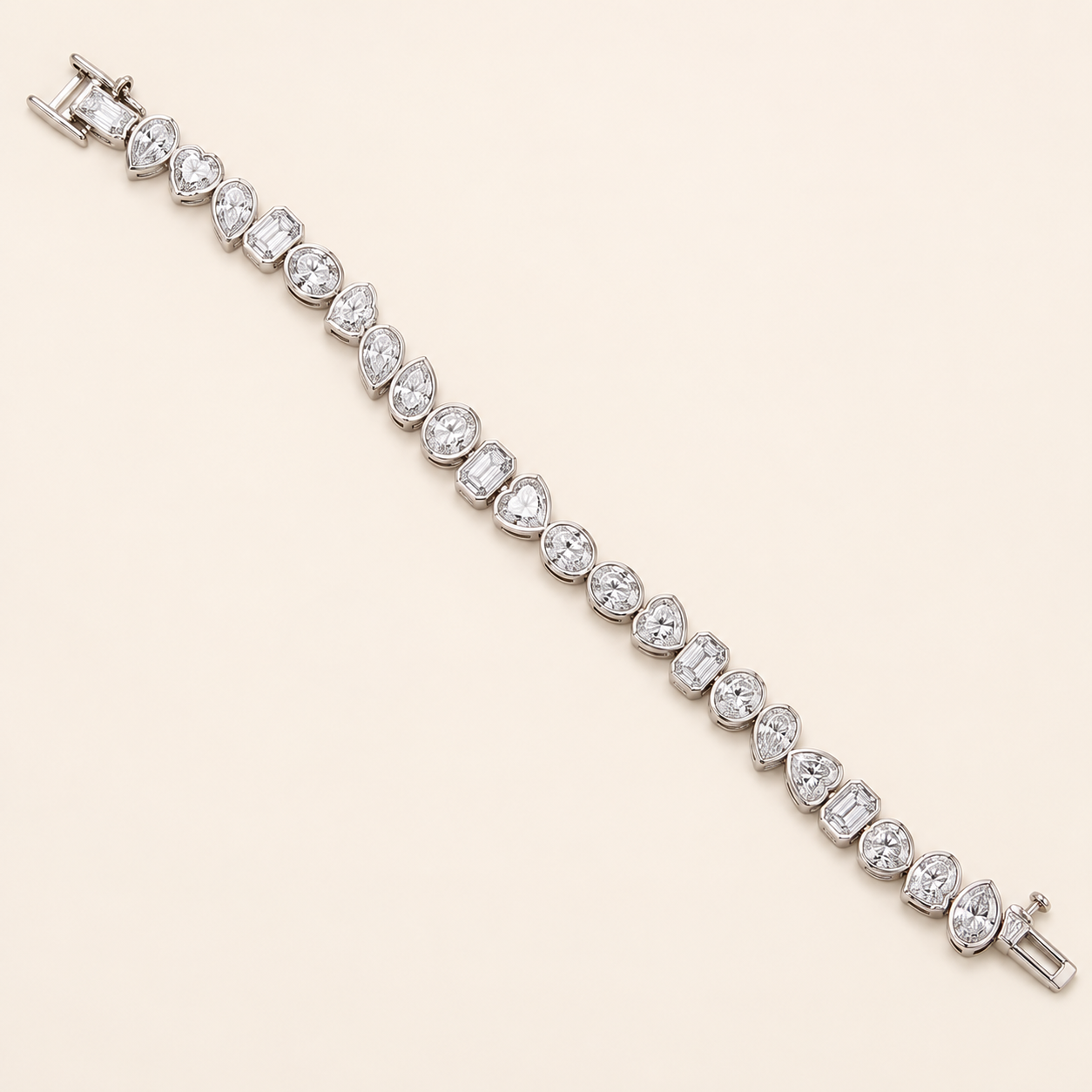 A silver tennis bracelet featuring a continuous line of clear round-cut and marquise-cut gemstones, displayed diagonally on a solid light beige background.