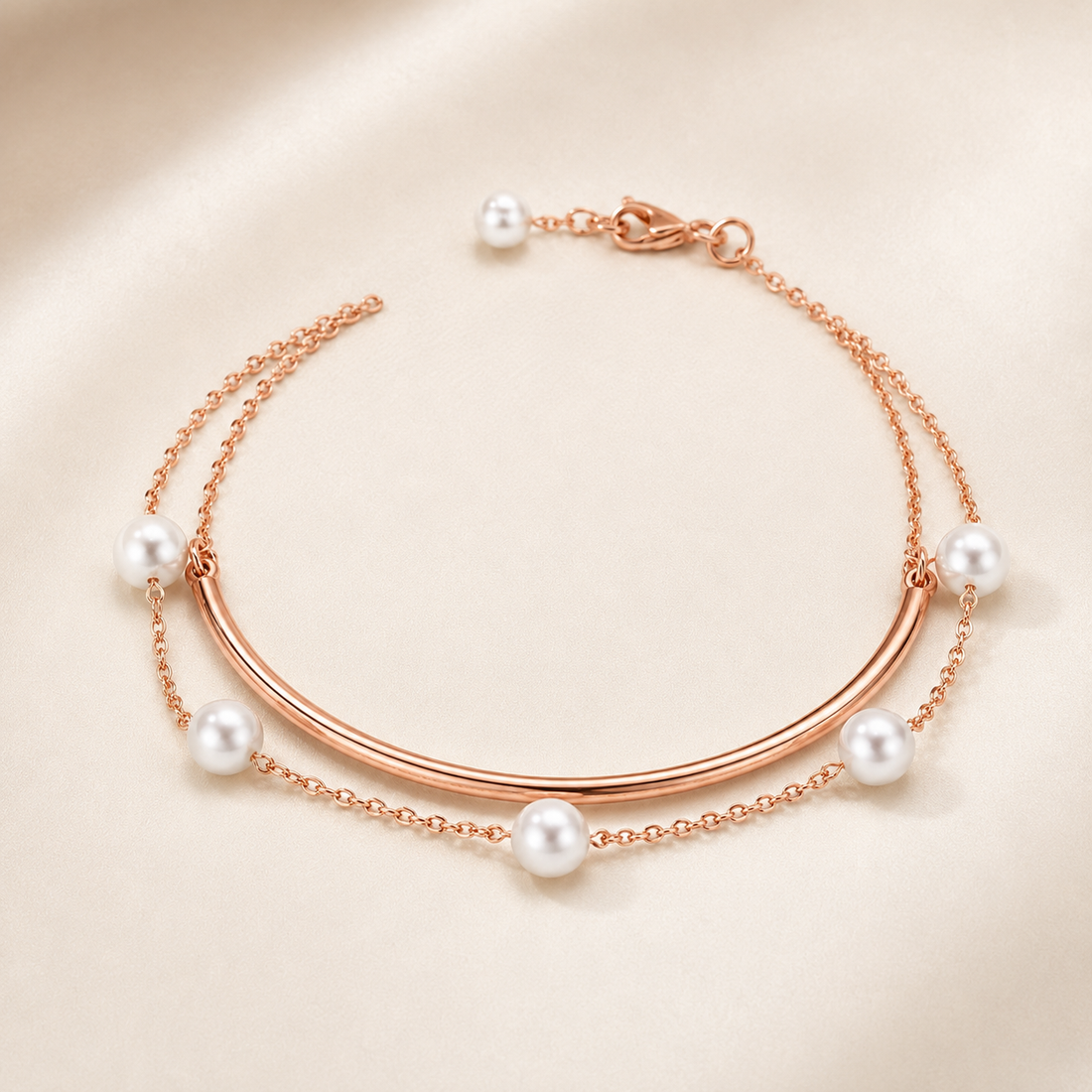 Rose gold double-layered bangle bracelet with white freshwater pearls, displayed on a soft beige satin background.