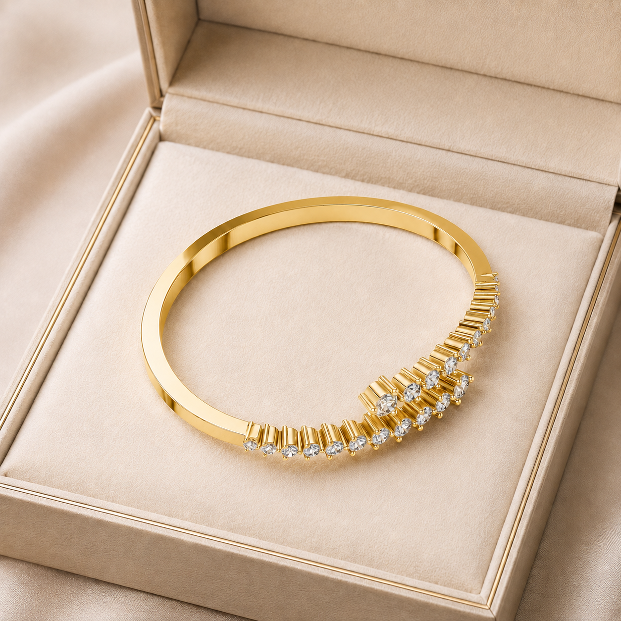 A polished gold bangle bracelet with a curved row of clear stones, displayed inside an open beige jewelry box.