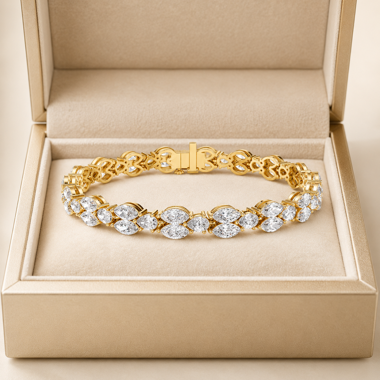 A gold tennis bracelet with marquise and oval-cut clear stones, displayed inside an open beige jewelry box.