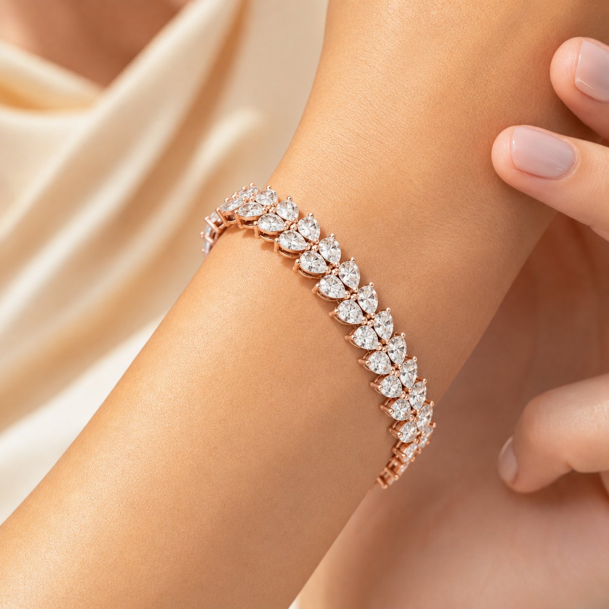 A close-up of a rose gold bracelet with a line of sparkling clear gemstones, worn on a woman's wrist against a soft beige background.