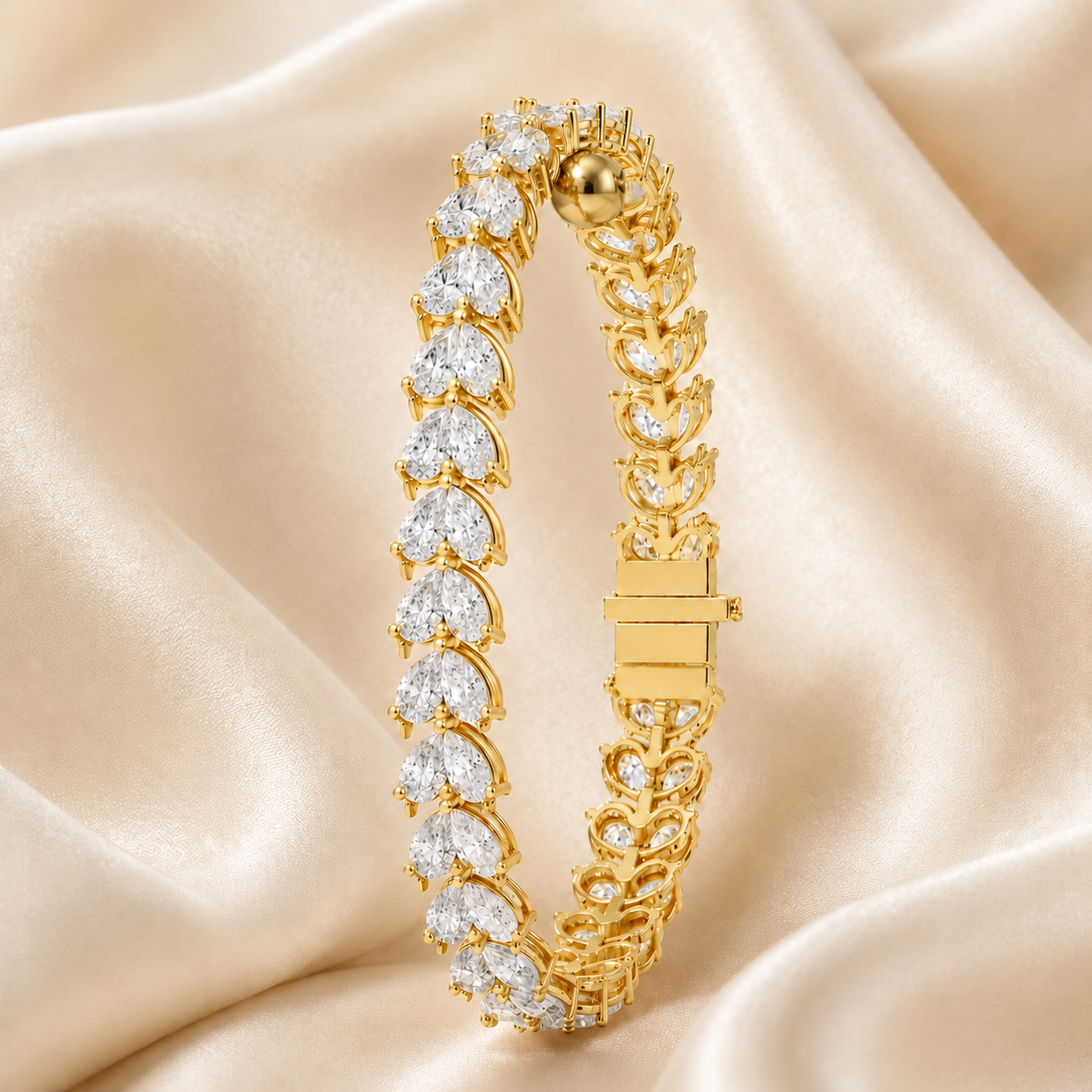 A gold tennis bracelet adorned with clear heart-shaped and round gemstones, displayed on draped champagne-colored satin fabric.
