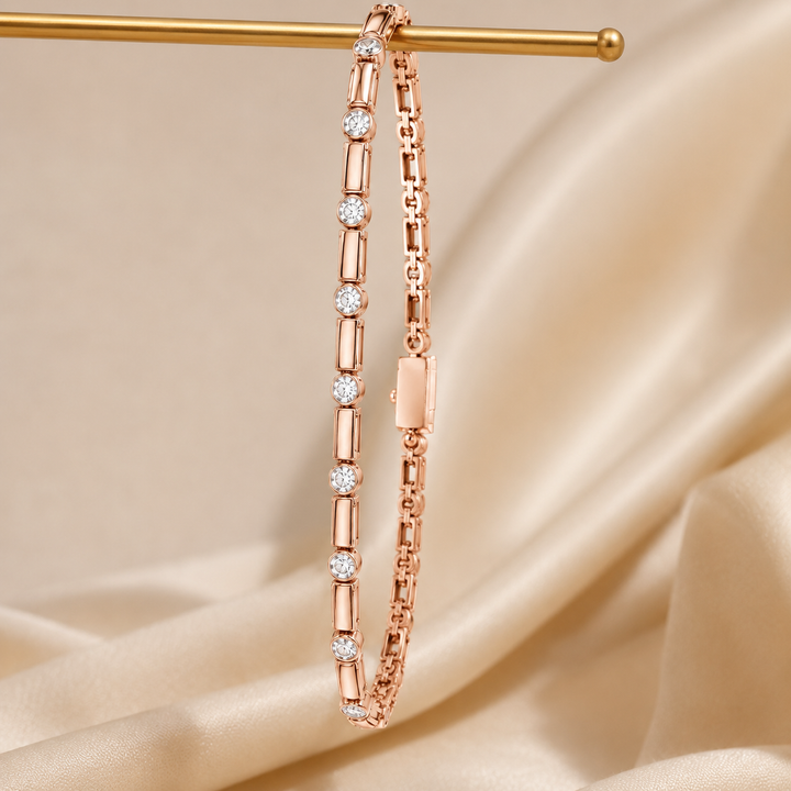 A rose gold tennis bracelet with round and baguette-cut diamonds, hanging from a gold display rod against a draped beige satin fabric background.