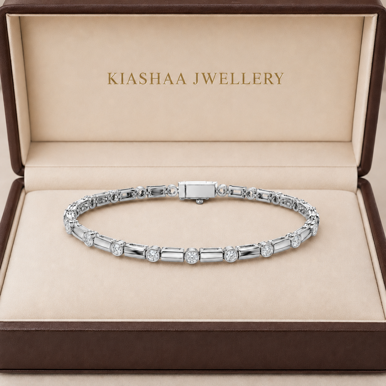 A silver tennis bracelet with baguette and round-cut stones, displayed inside an open brown jewelry box with a beige lining. The inside lid is printed with the brand name 'KIASHAA JEWELLERY'.