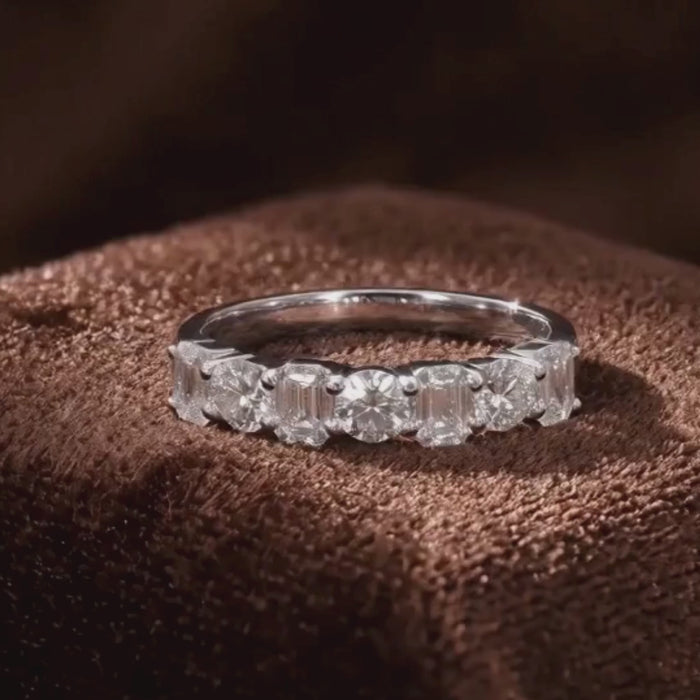 Alternating emerald and round brilliant diamond half eternity band