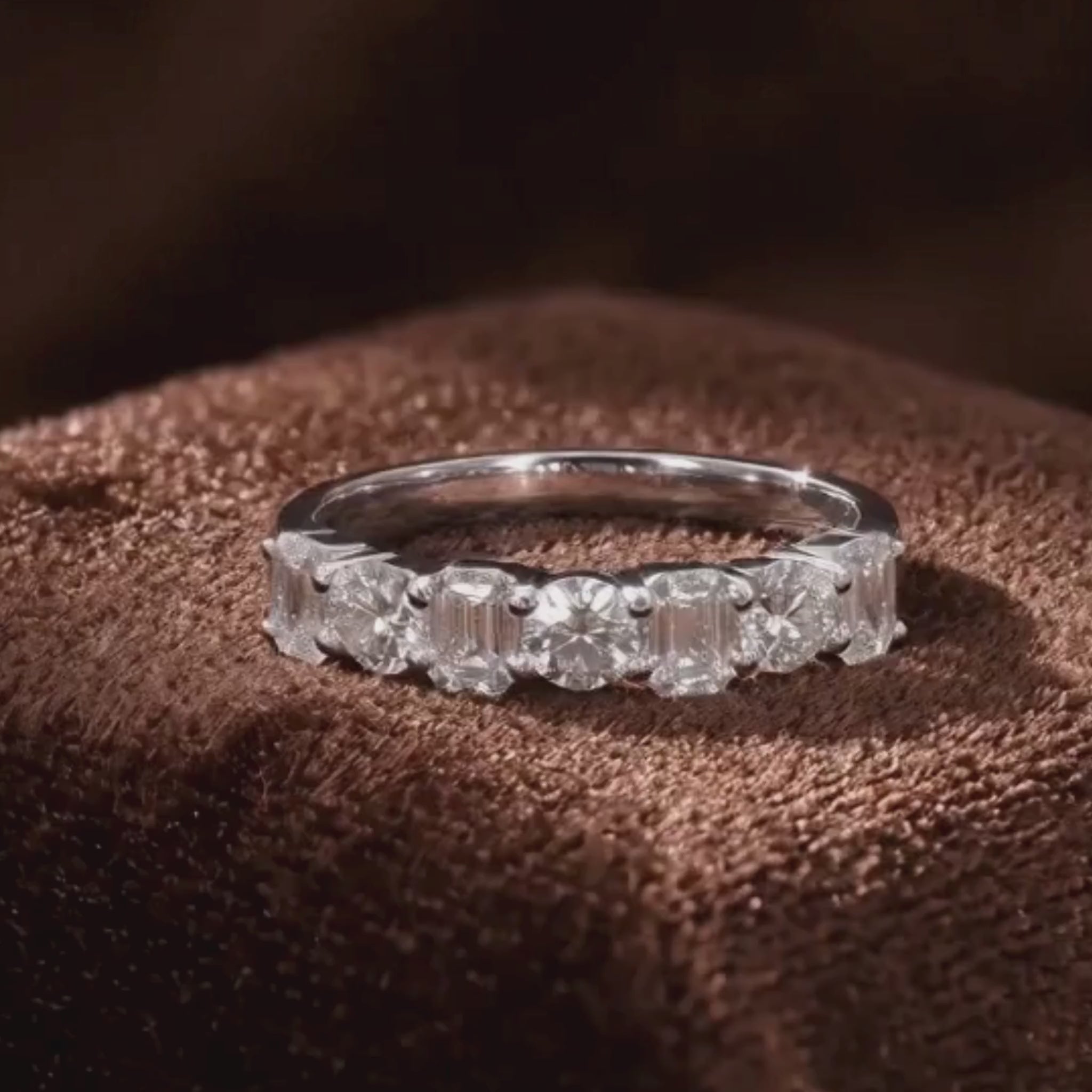 Alternating emerald and round brilliant diamond half eternity band
