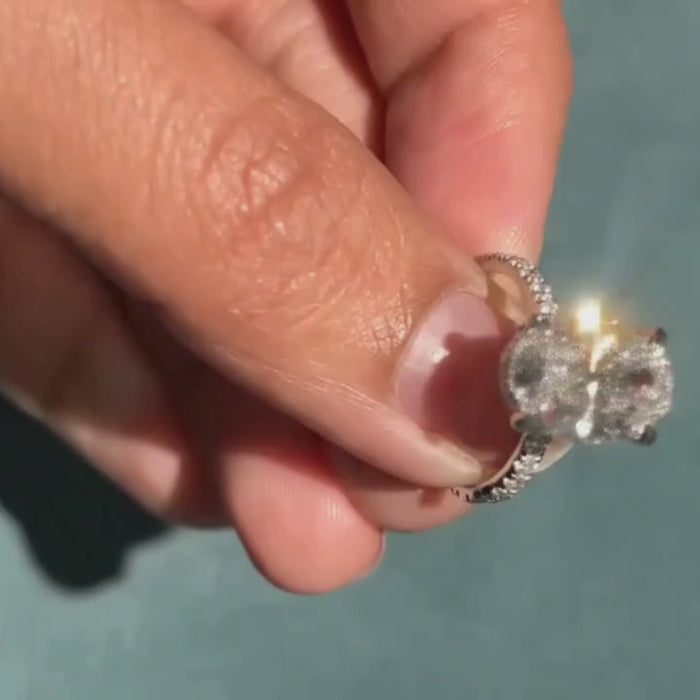 Four-prong oval diamond engagement ring with sparkling shoulders